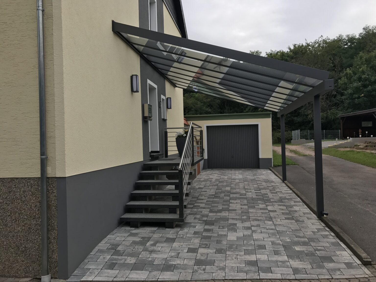 Glas-Vordach in Anthrazit über Hauseingang und Zufahrt