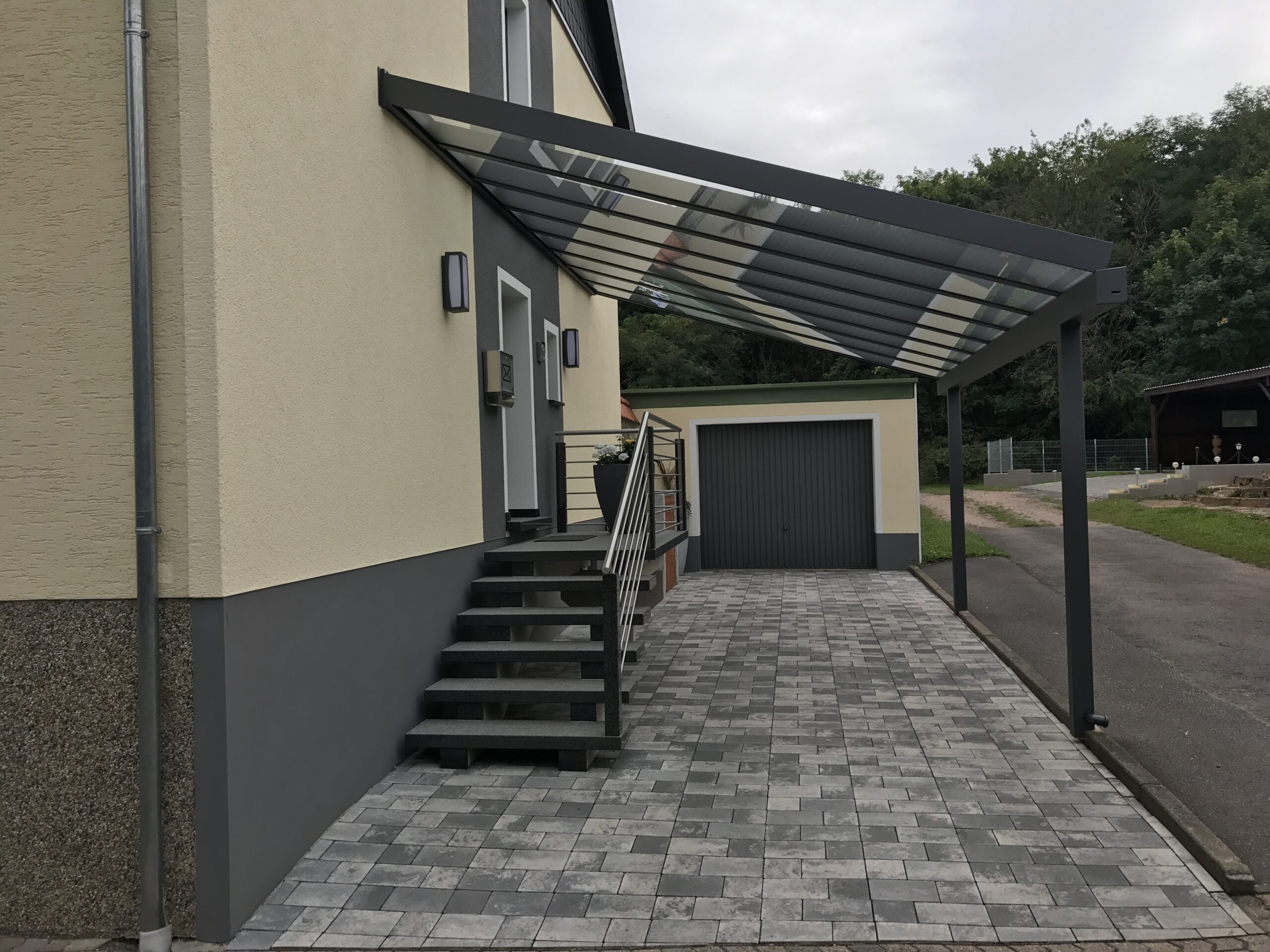 Glas-Vordach in Anthrazit über Hauseingang und Zufahrt