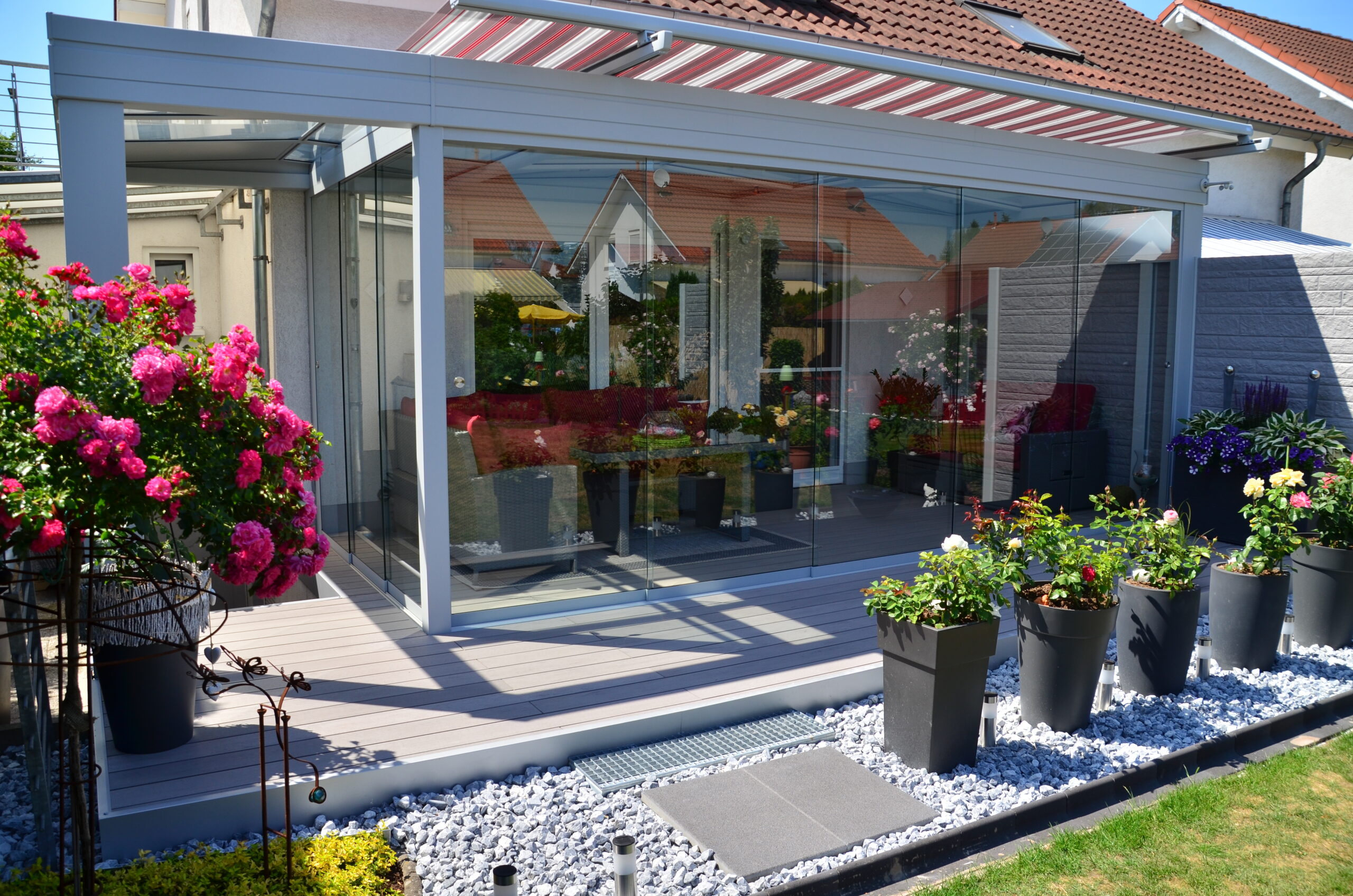 Sommergarten mit geschlossener Glasschiebeanlage und Markise
